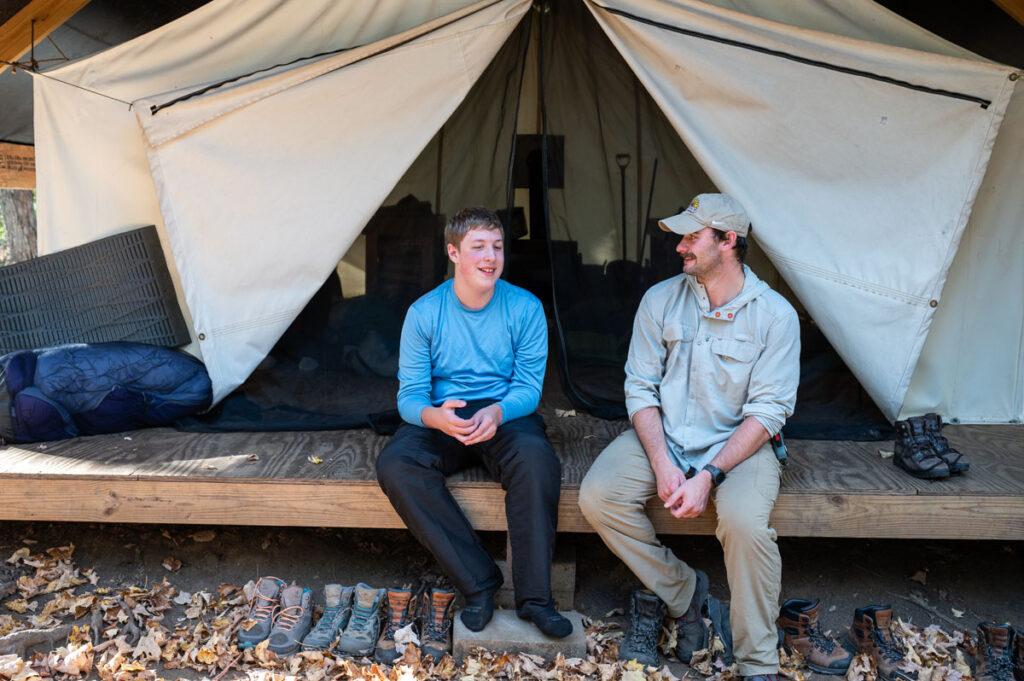 Summit Achievement student and staff conversing in front of a tent